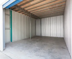 Empty metal storage unit with concrete floor.