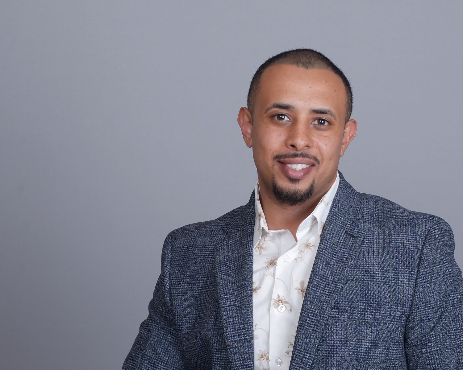 A man in a suit and tie is smiling for the camera.