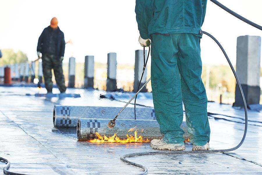 A man is standing on a roof with a torch.