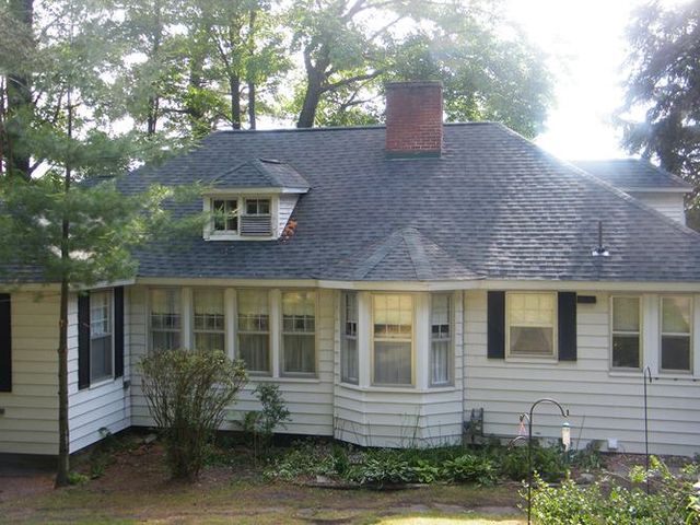 A white house with a blue roof and black shutters