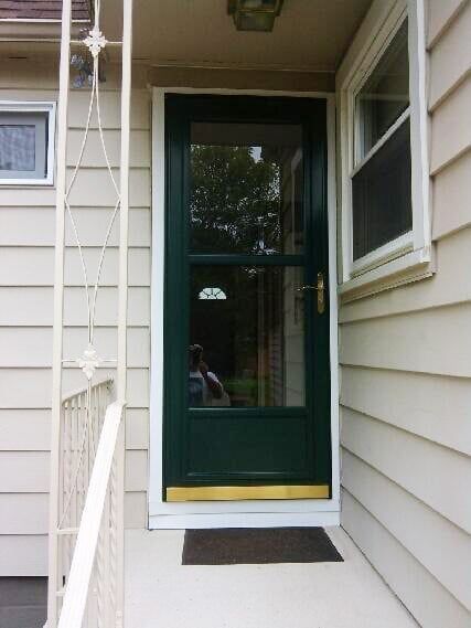 A white house with a green door and a window
