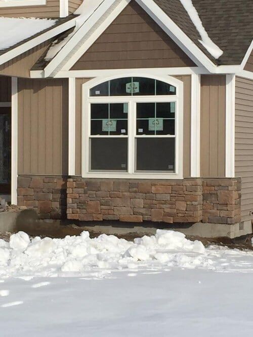 A house with a lot of snow on the ground in front of it