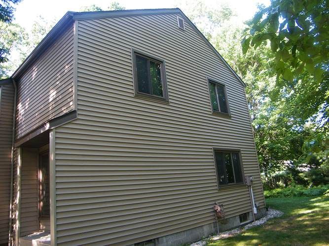 A large house with a lot of windows is surrounded by trees.