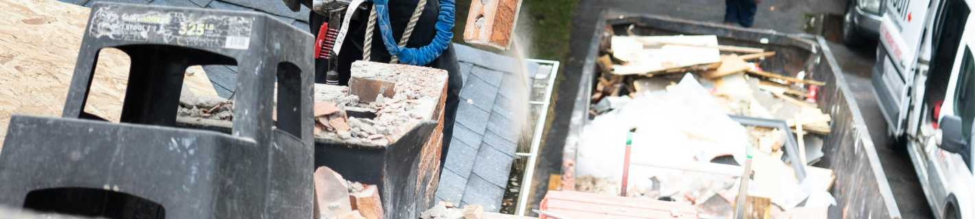 A cluttered outdoor scene featuring a black step stool, bricks, and a vehicle.