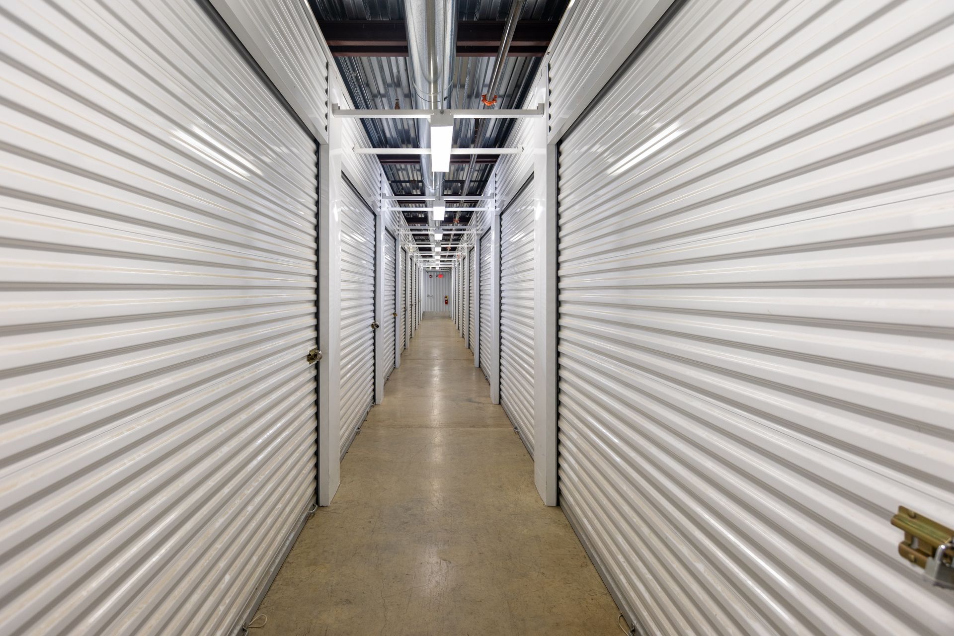 Interior view of storage units in a long hallway, with open doors.