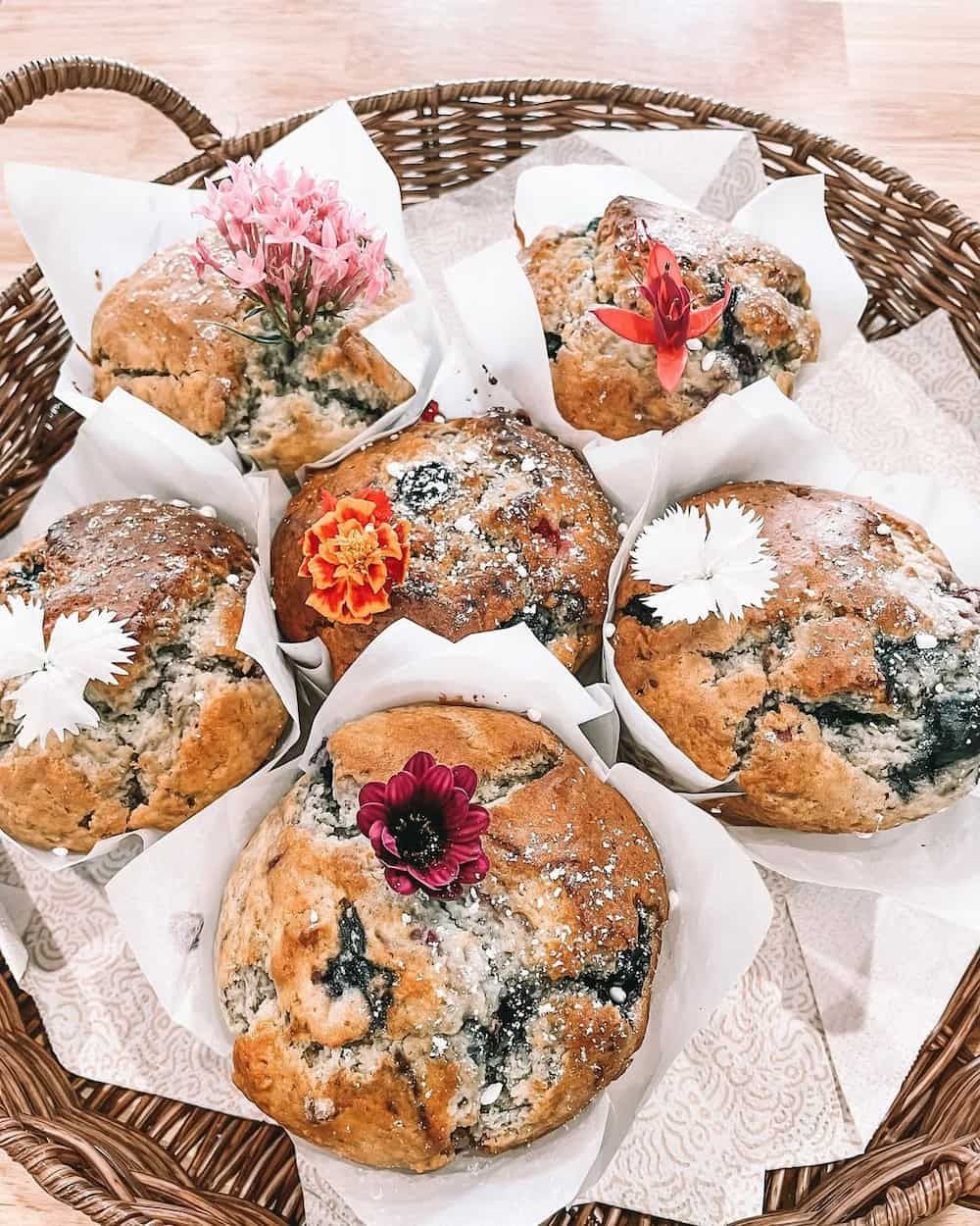 A Basket Filled With Muffins With Flowers on Top of Them — Swish Cafe in Ballina, NSW
