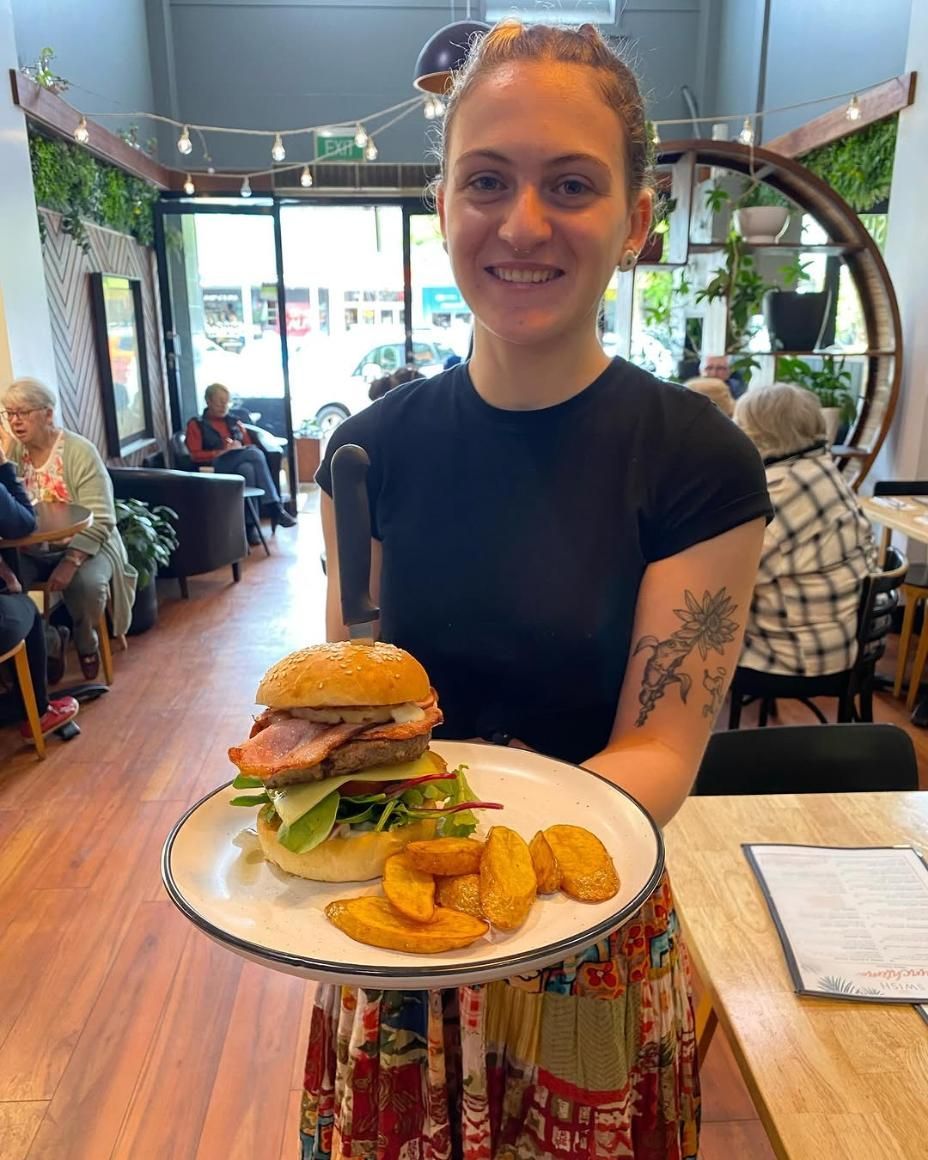 A Woman is Holding a Plate of Food in a Restaurant — Swish Cafe in Ballina, NSW