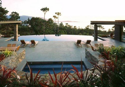 A large swimming pool surrounded by chairs and plants