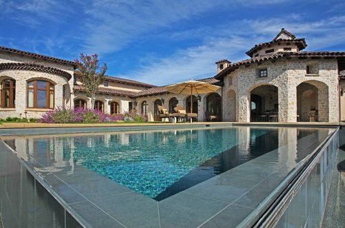 A large house with a swimming pool in front of it.