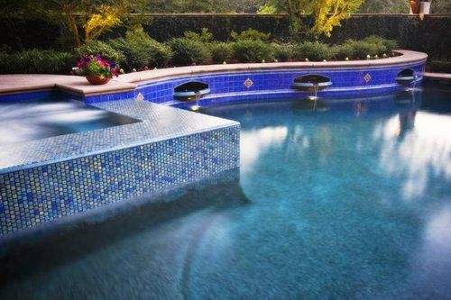 A large swimming pool with blue tiles surrounding it