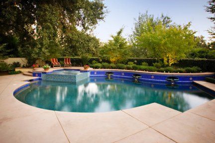 A large swimming pool with a hot tub in the middle