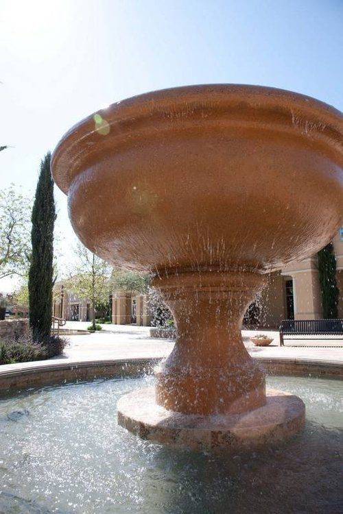 A large fountain with water coming out of it in a park.