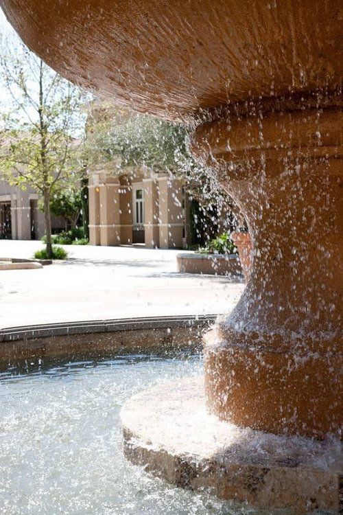A fountain with water coming out of it in front of a house