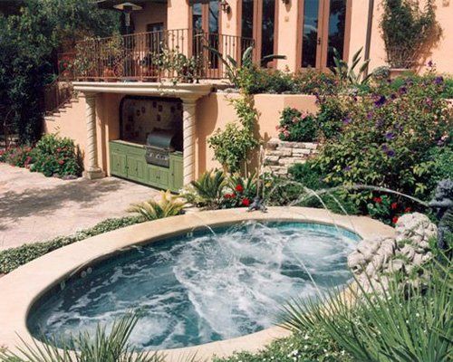 A hot tub with a fountain in front of a house