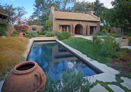 A house with a large swimming pool in front of it.