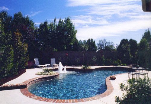 A large swimming pool with a fountain in the middle