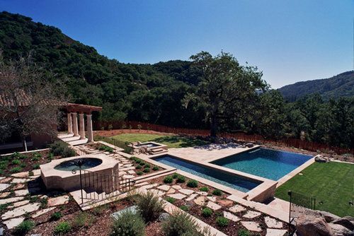 A large swimming pool with a hot tub in the middle of it