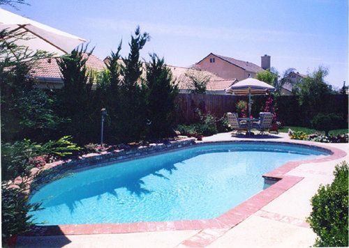 A large swimming pool with a gazebo in the background