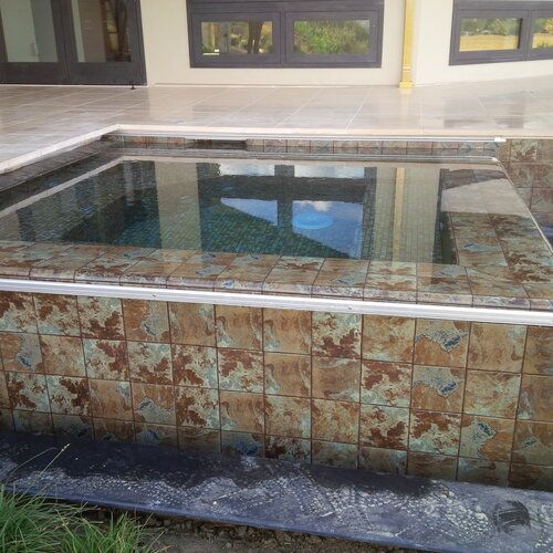 A swimming pool with a reflection of a building in it