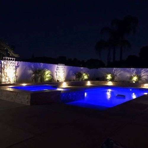 A large swimming pool is lit up at night