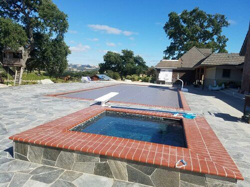 A swimming pool with a hot tub in the middle of it