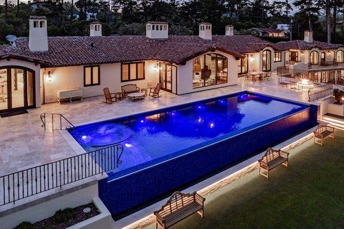 A large house with a large swimming pool in front of it