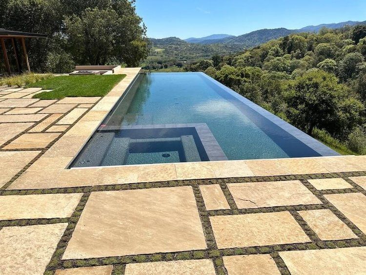 A very long swimming pool with a view of the mountains.