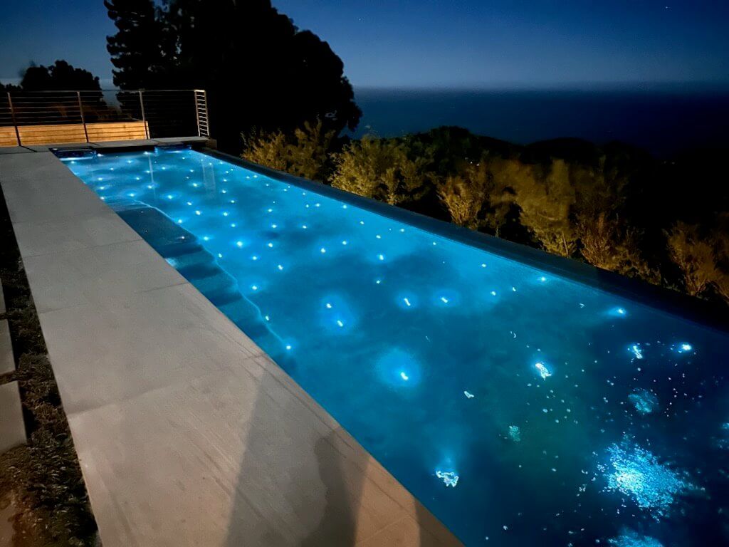 A swimming pool with a view of the ocean at night