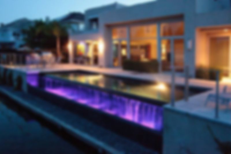 A house with a large swimming pool in front of it