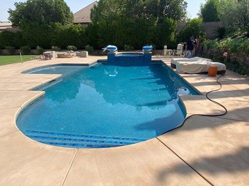 A large swimming pool is sitting on top of a concrete patio.