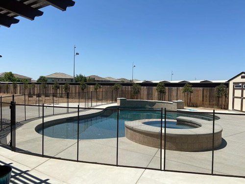 A large swimming pool with a glass fence around it.
