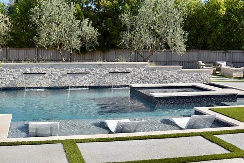 A large swimming pool with a stone wall surrounding it