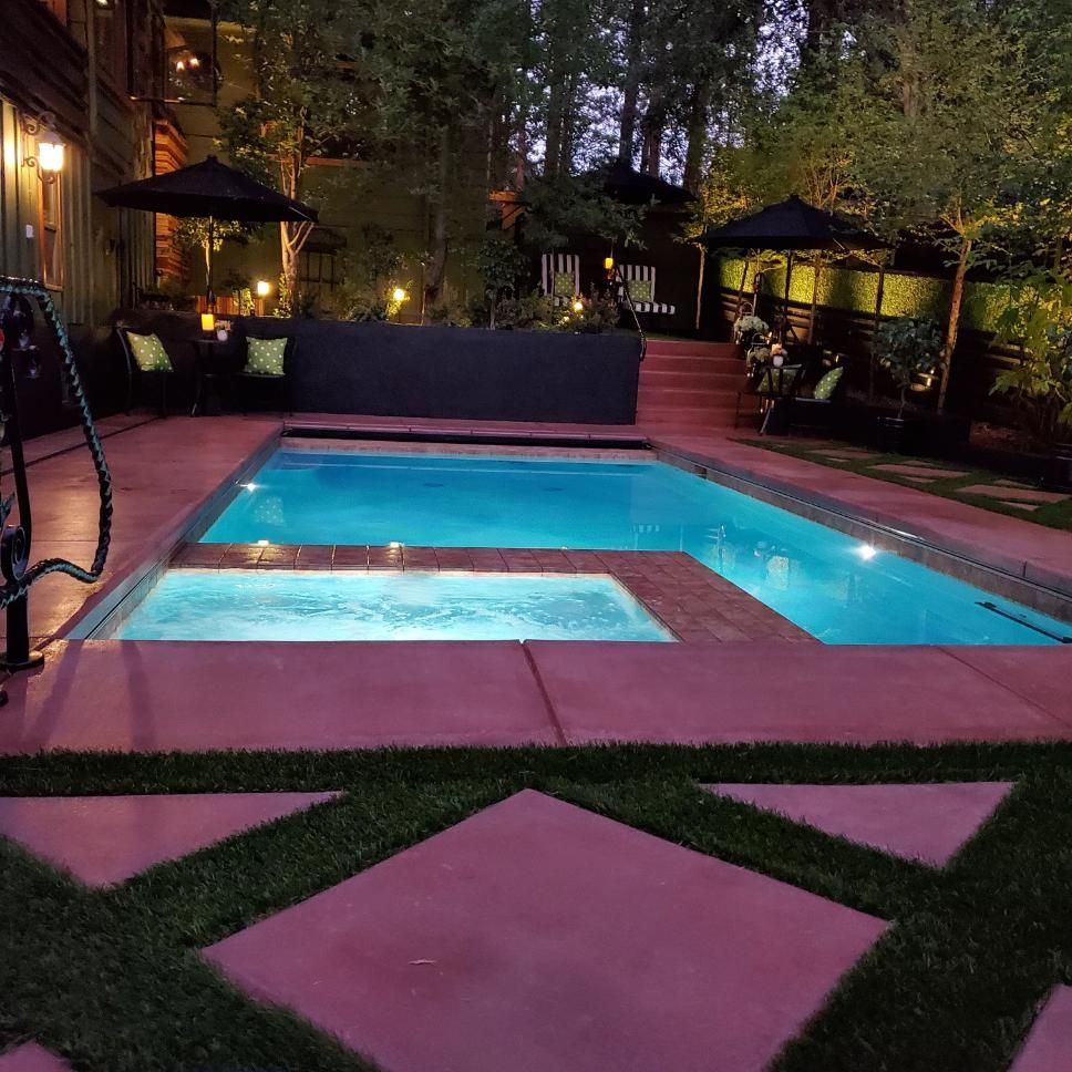 A large swimming pool is lit up at night