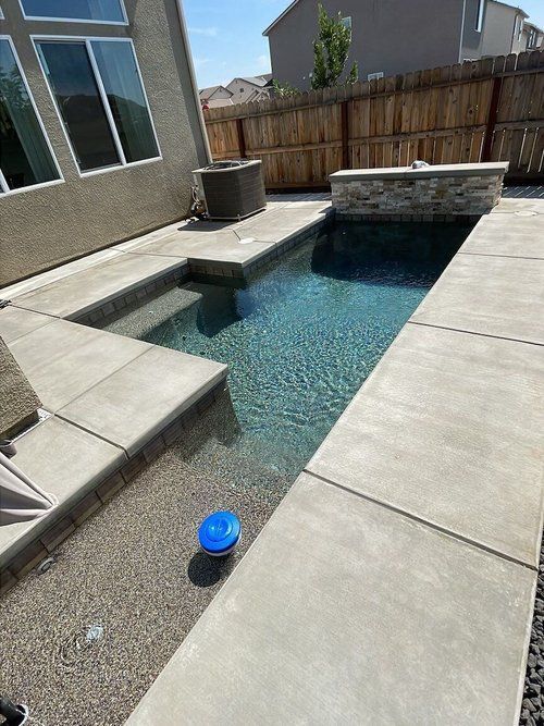 A small swimming pool in the backyard of a house.