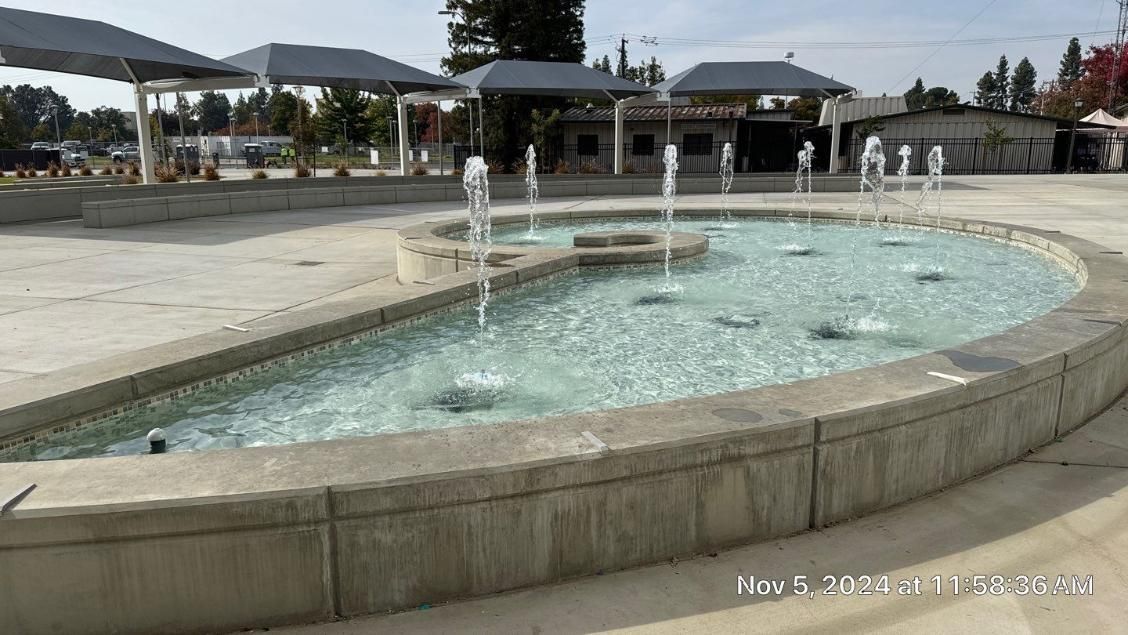 A fountain in a park with a lot of water coming out of it.