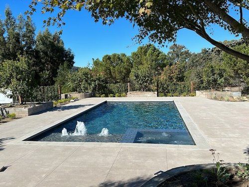 A large swimming pool with a fountain in the middle