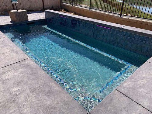 A swimming pool with a fence and a river in the background.
