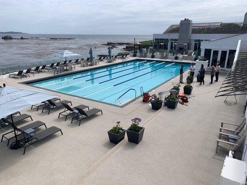 An aerial view of a large swimming pool surrounded by chairs and umbrellas.