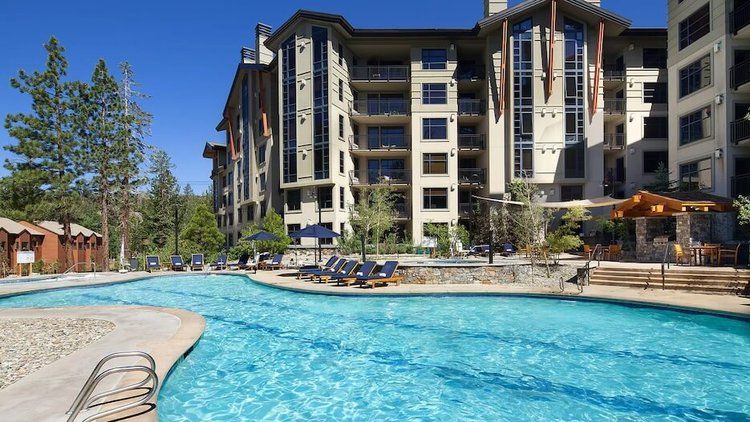 A large swimming pool in front of a large building.