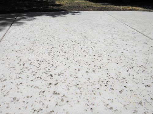 A concrete driveway with a lot of small stones on it