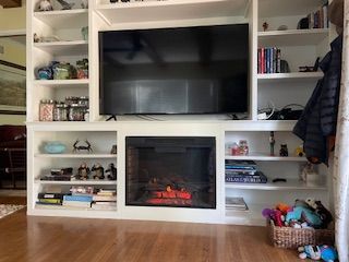A living room with a fireplace and a flat screen tv.