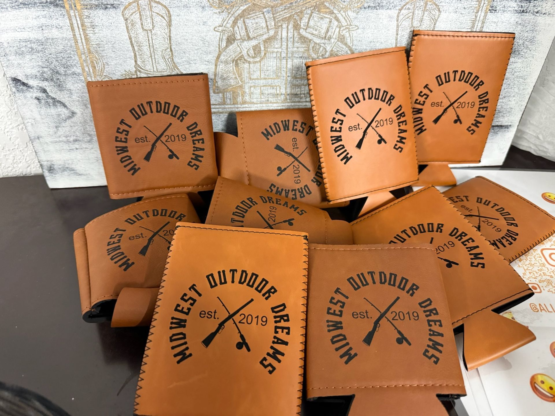 Brown drink koozies with black logo reading 