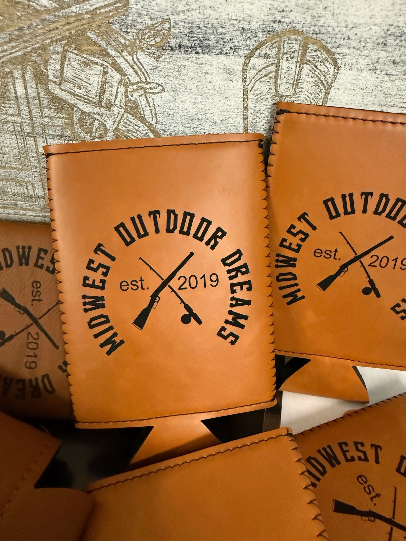 Multiple tan leather can koozies branded with 