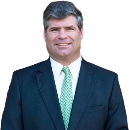 Man in a dark suit and green tie smiles, headshot.