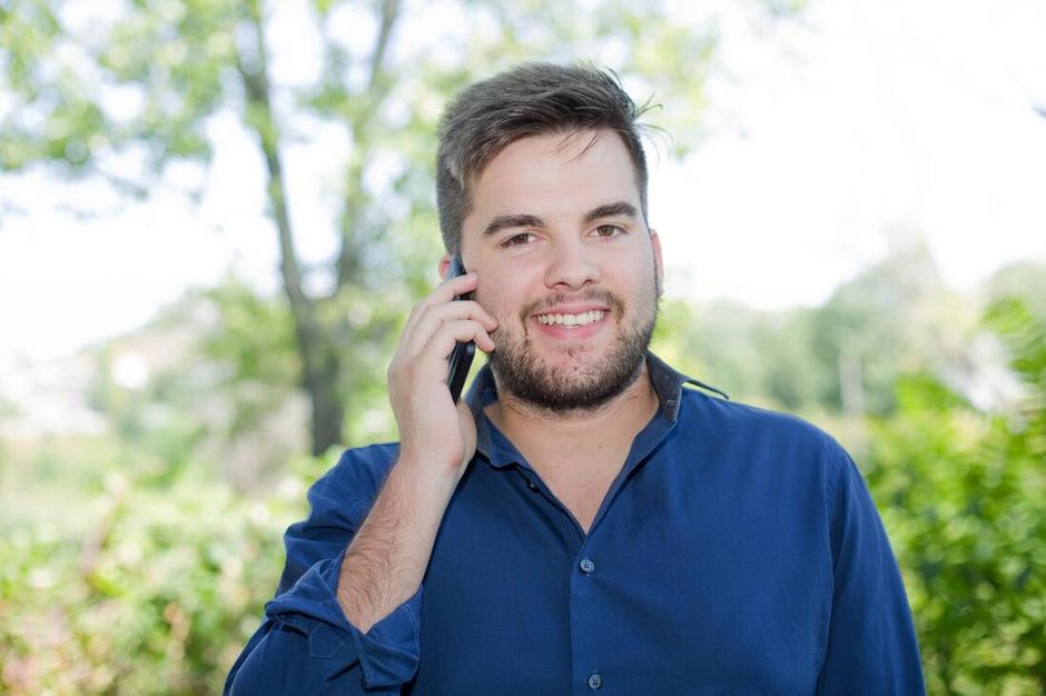 Man Calling on Cell Phone Outside in Yard