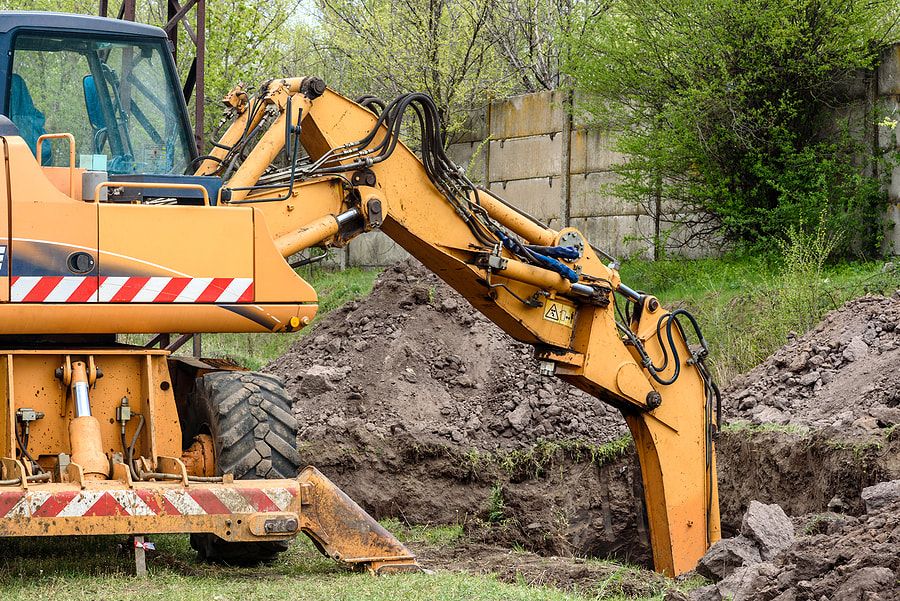 Excavator digging ditch on site for Maple Ridge Tree Service