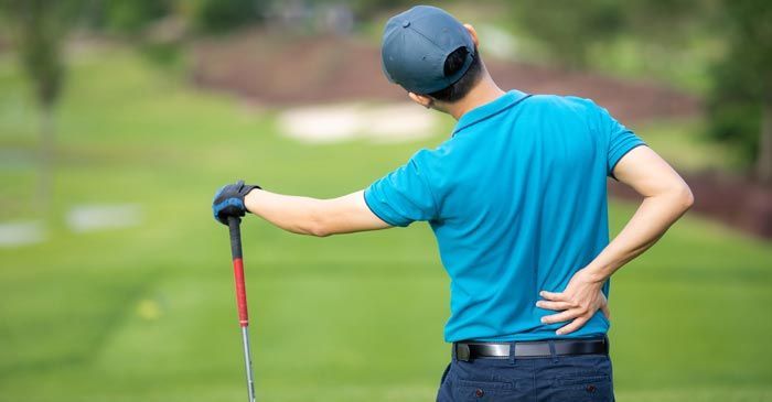A Golfer with back pain needi9ng Sports Injury Treatment - Dr. Louis Granirer Holistic Chiropractor