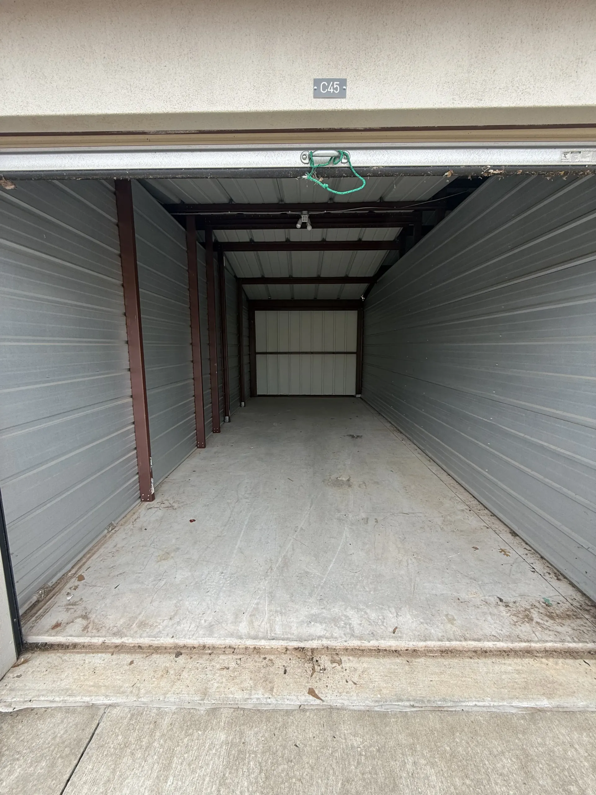 Empty garage interior with concrete floor and closed metal door at the back