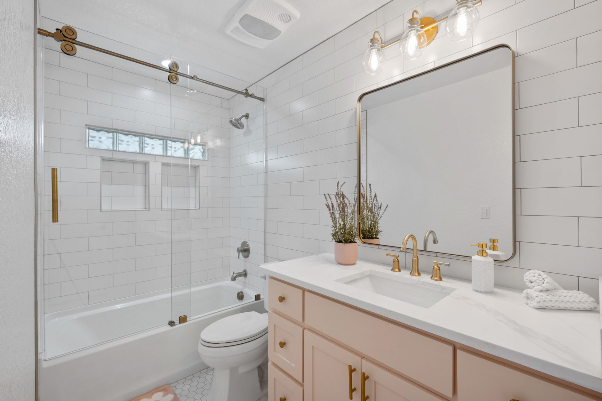 A bathroom with a sink , toilet , bathtub and mirror.