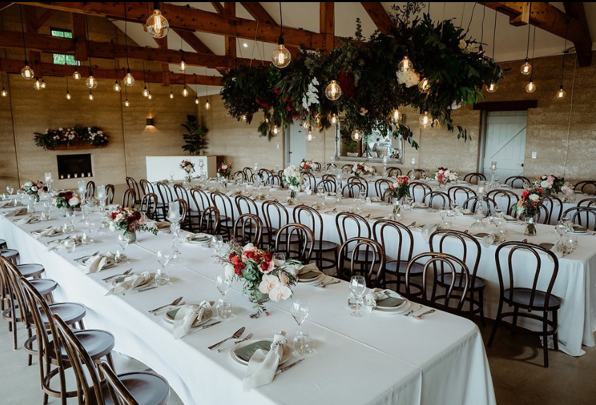 A large room with tables and chairs set up for a wedding reception.
